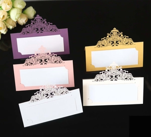 Detail of laser-cut wedding place cards with intricate patterns in various colors