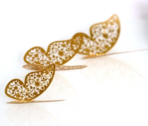 Macro detail of golden 3D hollow butterfly wall stickers with intricate floral patterns