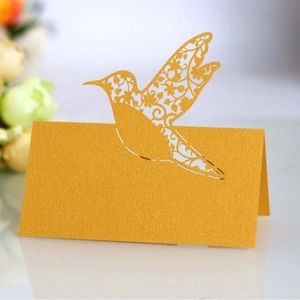 Golden laser-cut hummingbird place card for wedding table decor and seat identification