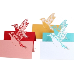 Laser cut hummingbird wedding place cards in red pink yellow teal and white cardstock