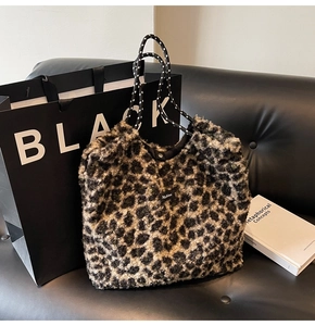 Detail of plush leopard print tote bag featuring woven rope handles and snap button closure