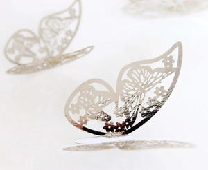 Macro view of 3D silver hollow butterfly stickers with laser cut floral patterns