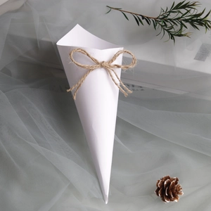 Close-up of white wedding confetti cones with twine bow for wedding petals and favors