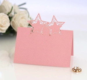 Detail showing pink laser-cut star place card with a delicate pearlescent paper texture