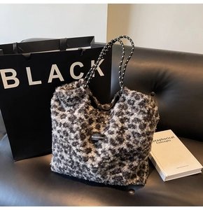 Detail of plush leopard print tote bag featuring woven handles and Moonshine label