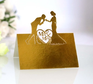Detail showing golden laser-cut Mr & Mrs wedding place card with kiss silhouette