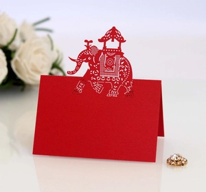 Detail of red laser-cut elephant place card with intricate patterns for wedding table