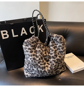 Detail view of plush leopard print tote bag with rope handles on a leather sofa