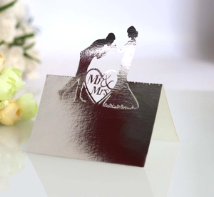 Macro shot of silver foil wedding place card with laser cut Mr & Mrs heart silhouette