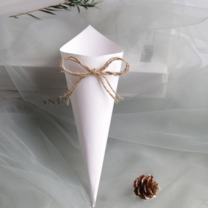 Close-up of white paper wedding confetti cone with a decorative natural jute twine bow