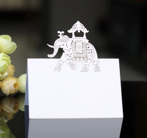 Detailed laser-cut white elephant table card with intricate floral patterns for weddings