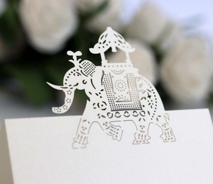 Elegant white laser-cut elephant place cards made of pearlescent paper for wedding decor