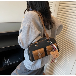Détail du sac polochon en toile avec poches en cuir marron et pendentif ours mignon