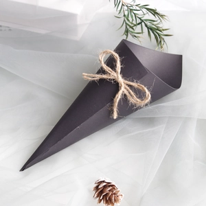 Detail of black kraft paper wedding confetti cone with natural jute rope bow on white mesh