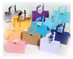 Detail view of laser-cut Mr & Mrs heart place cards in various metallic colors