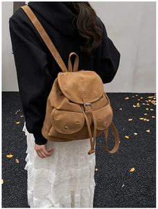 Rear view of a model carrying the vintage camel travel backpack on an autumn street