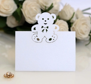 Close-up of glittery white place card with laser-cut bear design and heart detail