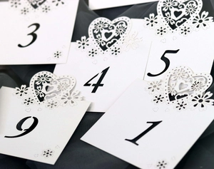 Laser-cut white heart wedding table numbers 1-10 with floral hollow engraving