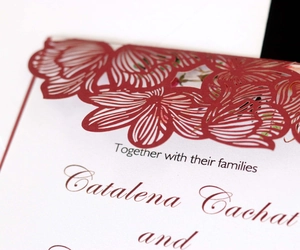 Elegant laser cut red floral wedding invitation card with intricate hollowed patterns