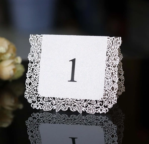 Laser cut pearl white wedding table card with number one and floral lace edges