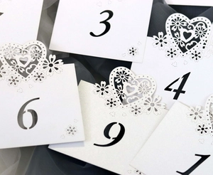Elegant laser-cut heart wedding table numbers in white cardstock for event seating