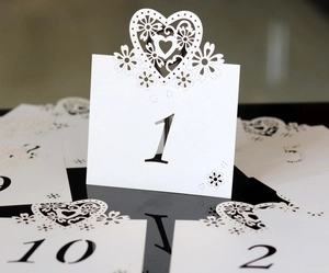 Elegant white laser-cut wedding table numbers 1-10 featuring heart and floral cutout design