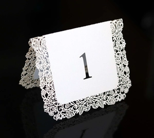 Detailed laser-cut lace floral pattern on white table number one card for weddings