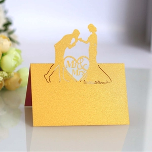 Golden laser-cut Mr & Mrs wedding place cards with elegant couple silhouette and heart cutout