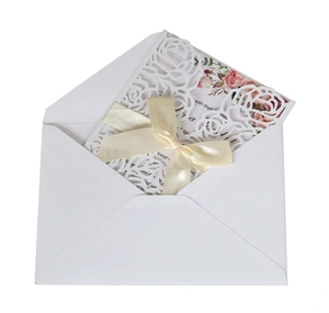 Detail of laser-cut rose hollow invitation with elegant bow and inner card