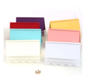 Laser cut lace wedding place cards in multiple colors including purple pink and white