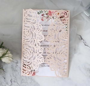 Detail of laser-cut rose invitation card with pink cardstock and floral inner paper