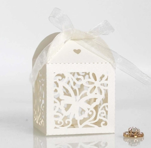 Macro shot of laser-cut butterfly hollow pattern on cream wedding favor paper gift box