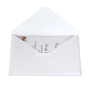 Close-up of laser-cut hollow wedding invitation with wave details and white envelope
