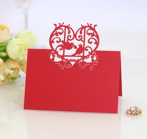 Elegant red laser-cut place cards with love birds and floral design for wedding table