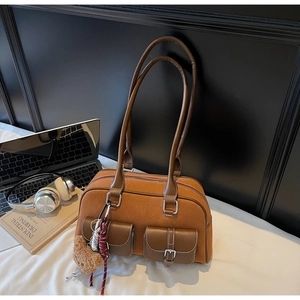Détails du sac Boston avec coutures contrastées et poches avant à boucles argentées