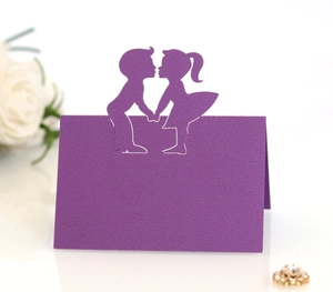 Purple laser-cut wedding place cards featuring a romantic boy and girl silhouette