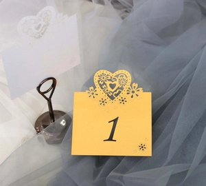 Detailed laser-cut heart pattern on yellow wedding table number card with numeral one