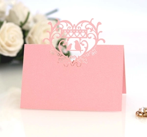 Pink laser-cut table card with intricate heart and bird hollow design for wedding decor
