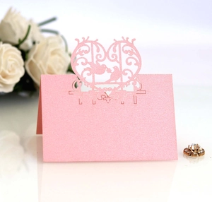 Pink laser-cut lovebird place cards for wedding tables with a pearlescent finish