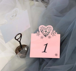 Laser-cut heart-shaped wedding table number card with floral hollow pattern detail