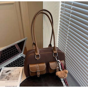 Vue détaillée du sac à bandoulière vintage marron avec texture en daim et poches