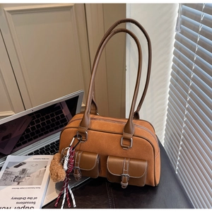 Détail du sac à bandoulière vintage marron en suédine avec un petit ours en peluche