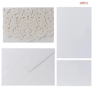 Detail of cream laser cut wedding invitation set with heart floral pattern and envelopes