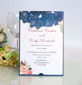 Elegant laser cut navy blue wedding invitation with floral insert and romantic flower props