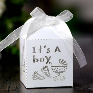 Detailed view of white laser-cut 'It's a boy' candy box with ribbon and stroller pattern