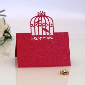 Détail de la carte de table découpée au laser avec motif cage à oiseaux en papier rouge