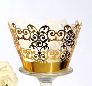 Close-up of golden laser-cut cupcake wrappers with elegant lace vine pattern
