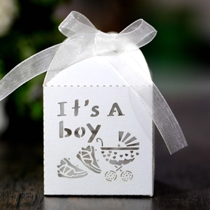Detailed macro view of laser-cut 'It's A boy' text and baby carriage design on candy box