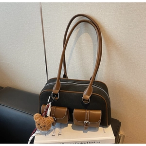 Vue détaillée du sac Boston en toile rétro avec garniture en cuir et charm petit ours