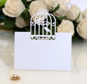Détail de marque-place mariage découpé au laser avec motif oiseau sur papier scintillant